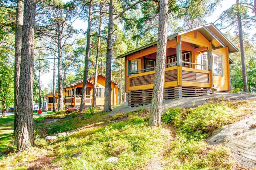 una gran casa amarilla en el bosque con árboles en Poroholman Lomakeskus en Rauma