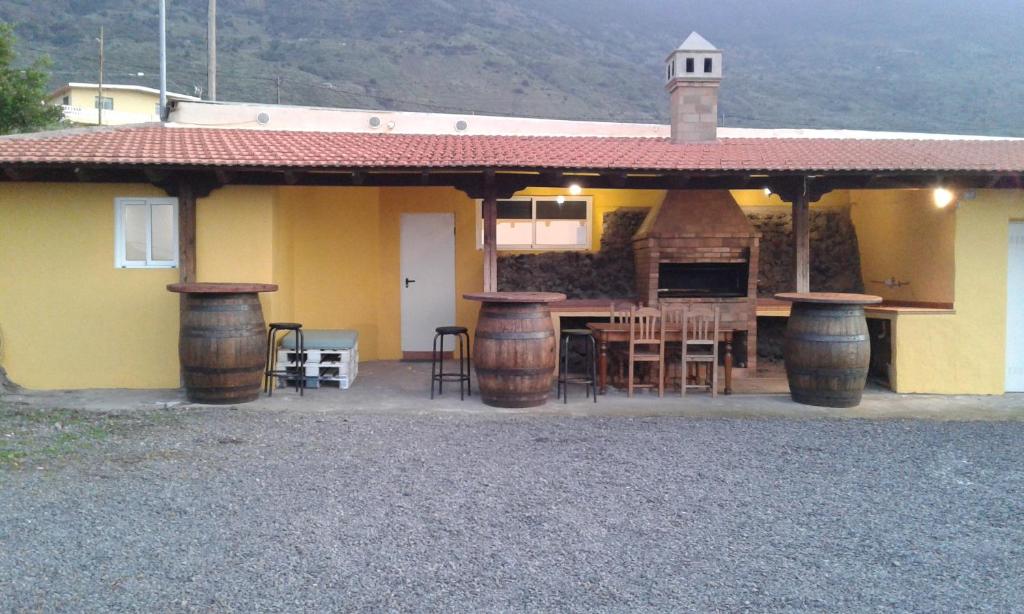 een huis met een patio met een tafel en een aantal vaten bij Casita con Barbacoa in Frontera