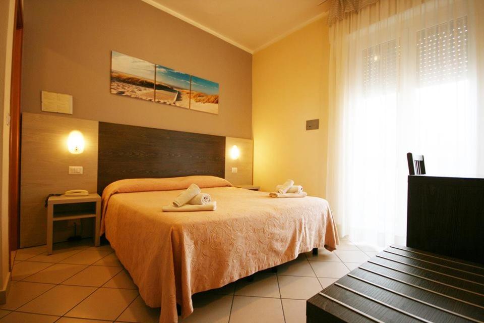 una camera da letto con un letto e due asciugamani di Hotel Senyor a Rimini