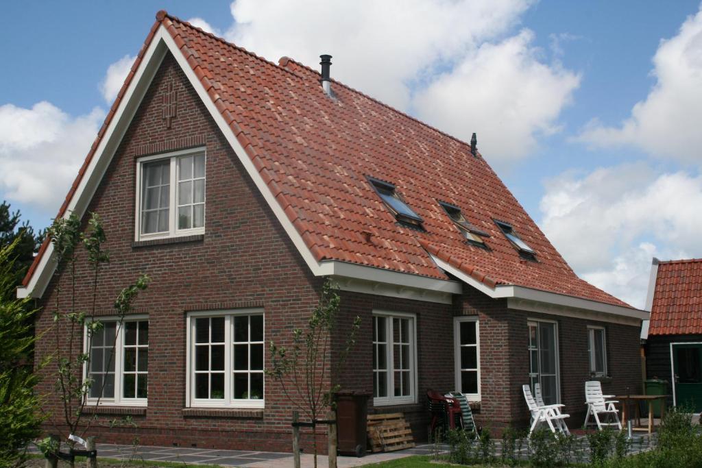 a large brick house with a red roof at B&B 't Meulweegje in Ouddorp