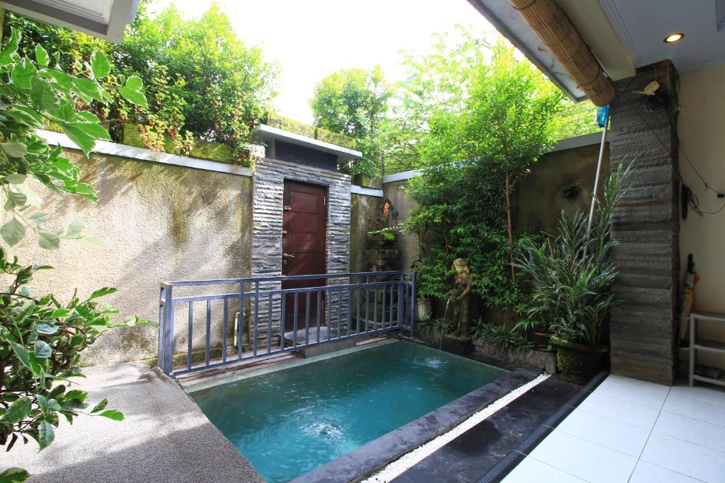 una pequeña piscina en un patio con árboles en Private Villa Wayan, en Ubud