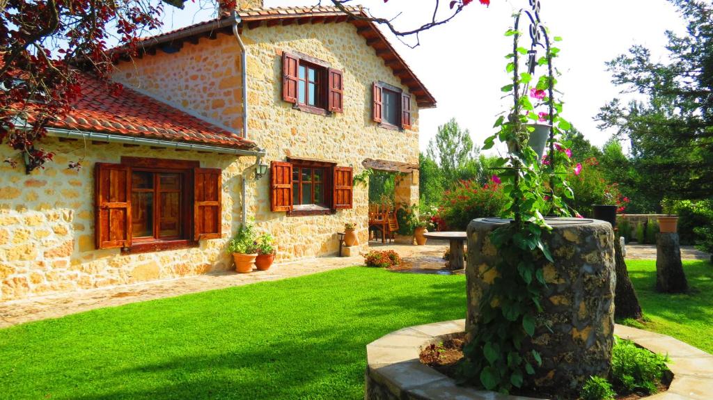 a stone house with a tree stump in front of it at Casa Rural El Covanchón in Prádena