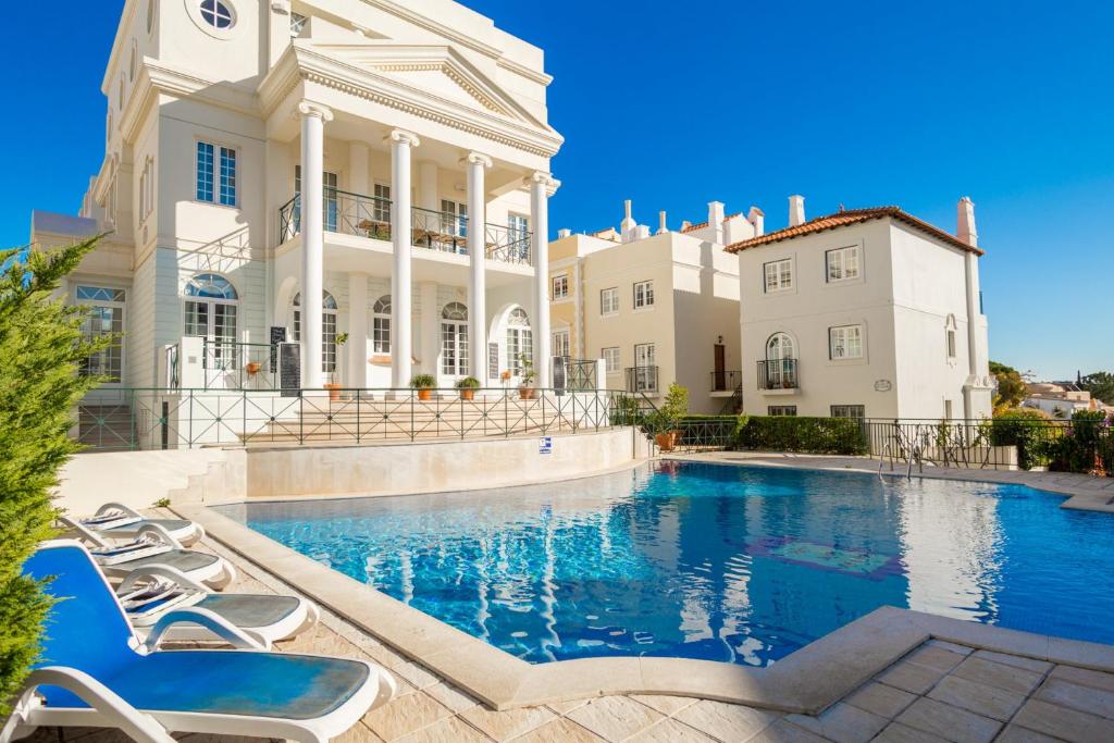 une demeure de caractère avec une piscine située en face d'un bâtiment dans l'établissement Akisol Vilamoura Gold III, à Quarteira