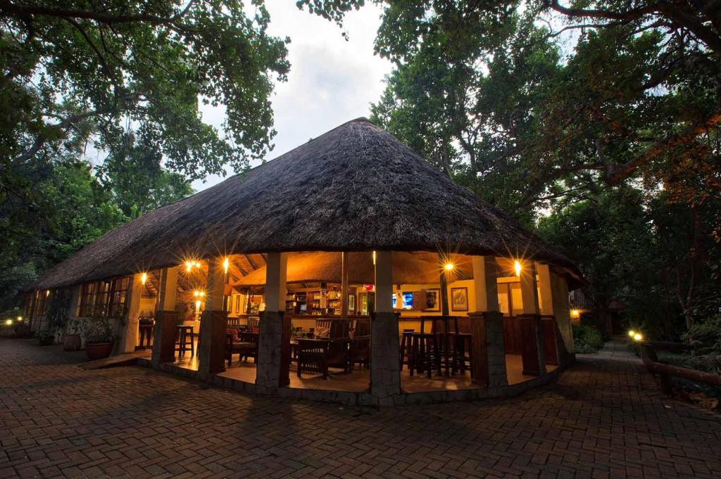 a building with a thatched roof with tables and chairs at Island Safari Lodge in Maun