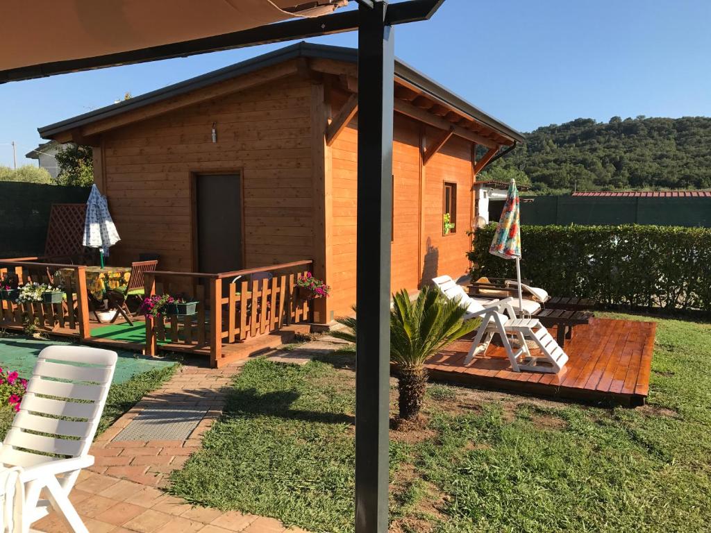 a house with a deck with two chairs and an umbrella at Chalet Impero in Scauri