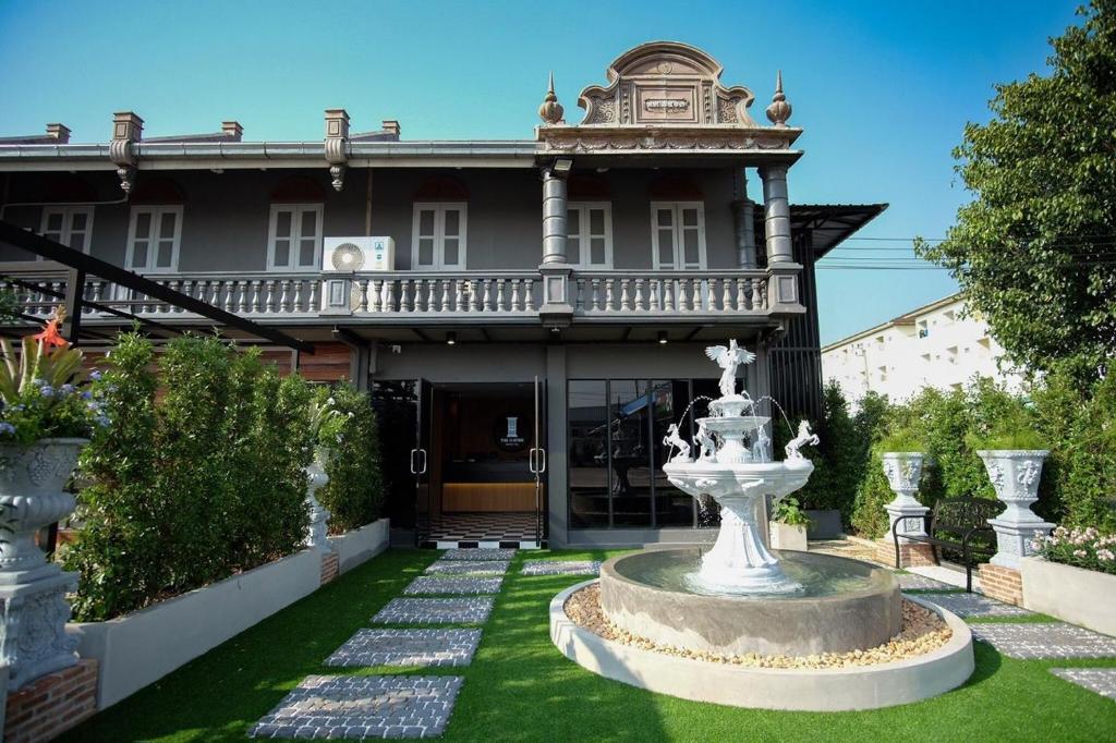 a large house with a fountain in the yard at The O-Zone Airport Inn in Lat Krabang