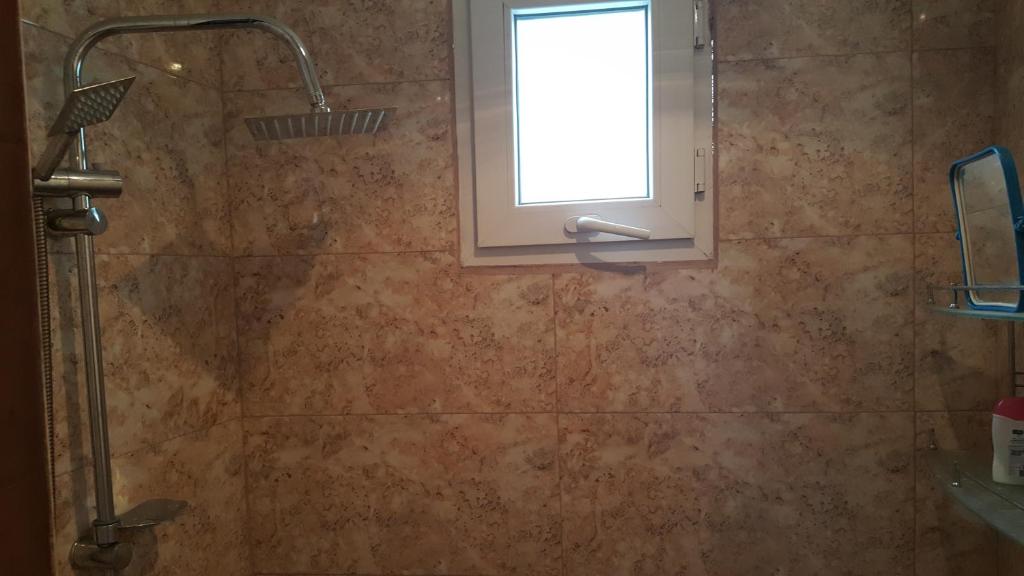 a bathroom with a shower with a window and a sink at Sabir's Apartment Old Town in Tbilisi City