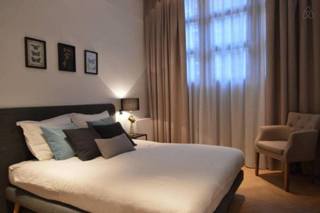 a bedroom with a large bed and a window at Romantic ground floor suite in Pijp near Sarphatipark in Amsterdam