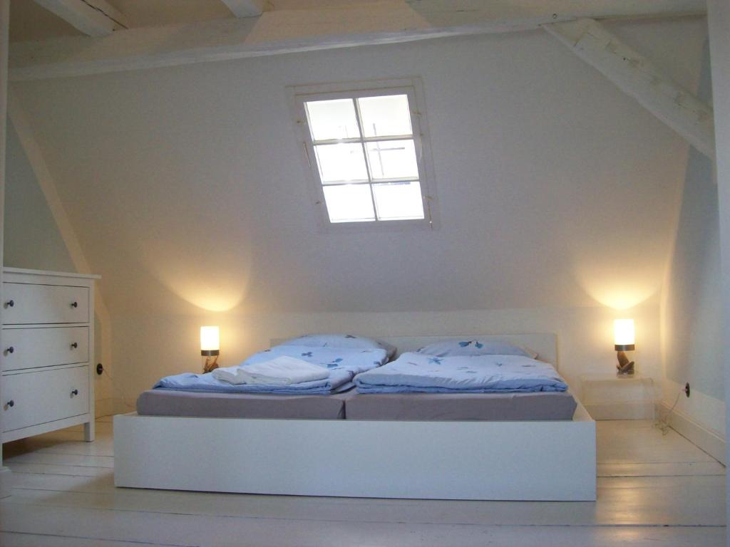een witte slaapkamer met een bed en een raam bij Ferienhaus St. Johannis in Werben