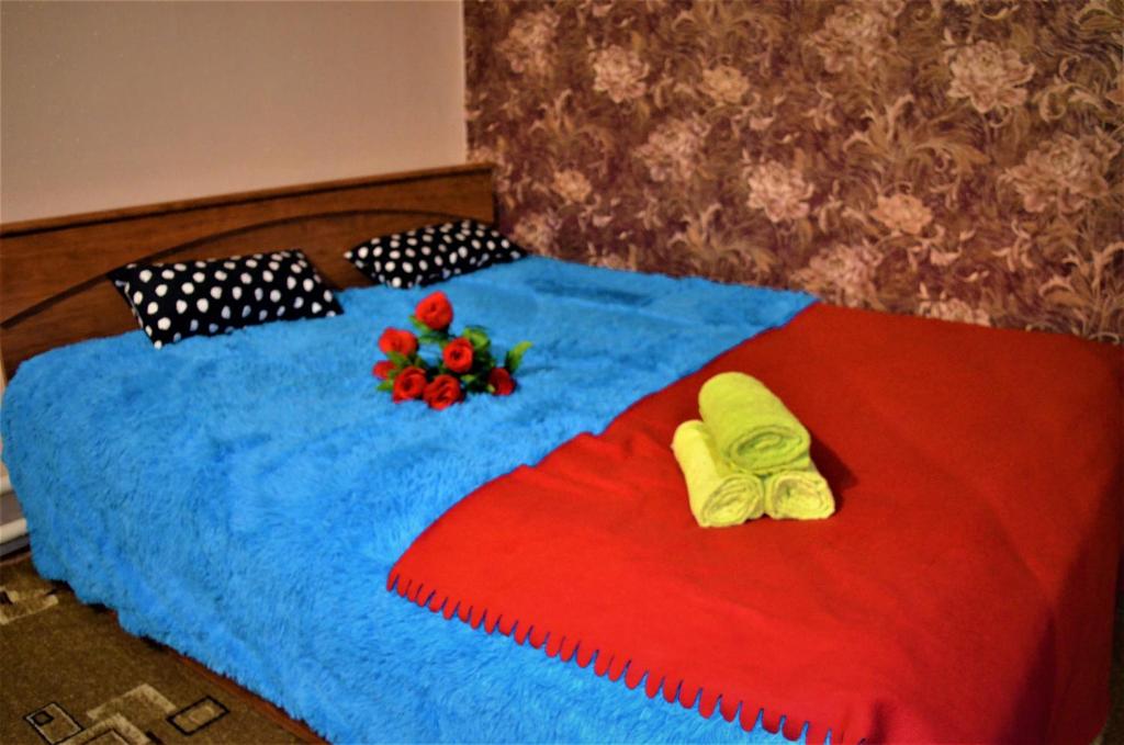 SalavatにあるВ центреのベッド1台(スリッパ2枚、花付)