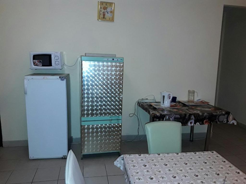 ベレホヴェにあるГотель АС Береговоの冷蔵庫、テーブル、電子レンジが備わる客室です。