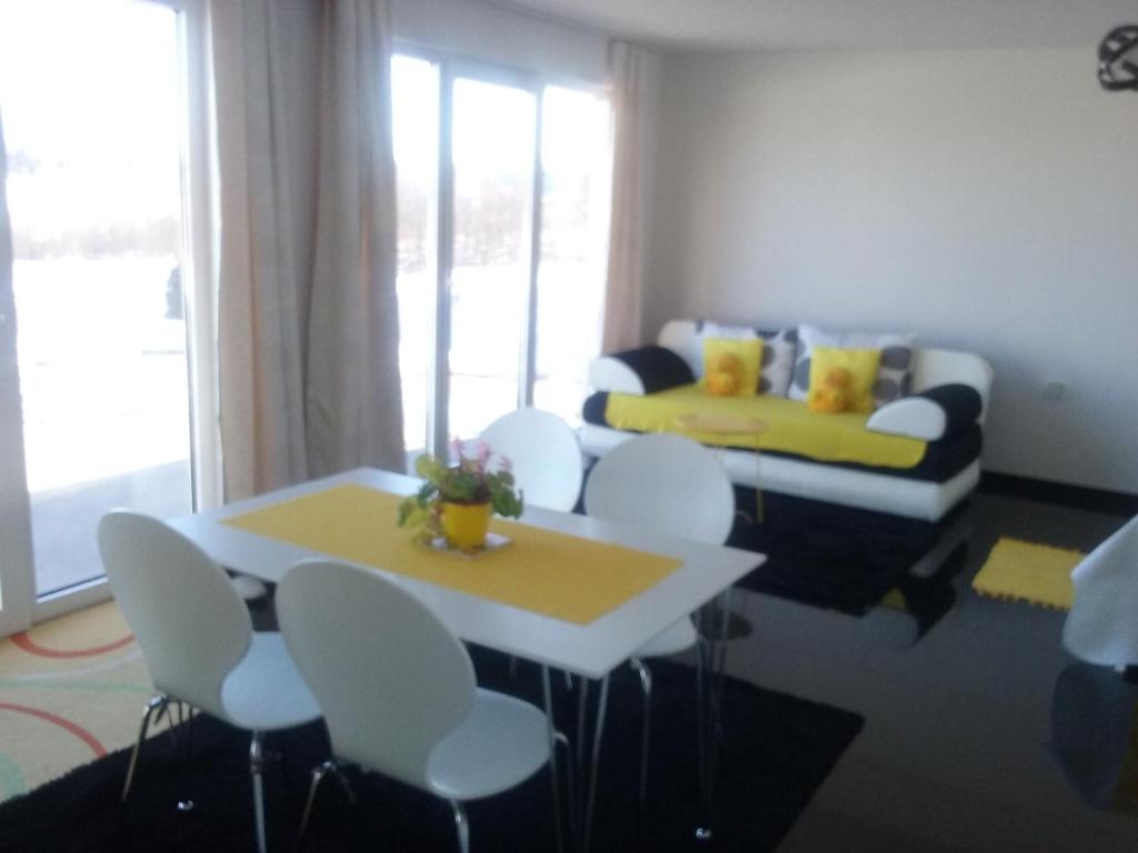 salon z białymi krzesłami, stołem i kanapą w obiekcie Apartment Melissa w mieście Rakovica