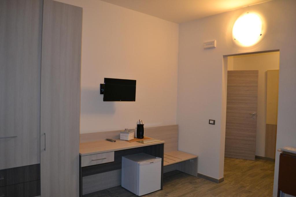 a room with a desk with a tv on the wall at La Chance in Ferrara