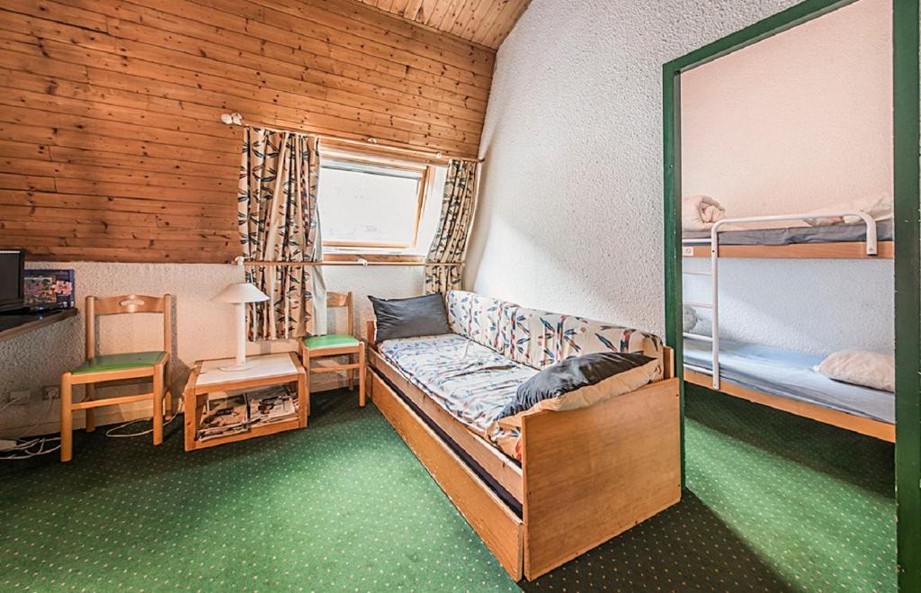 シャモニー・モンブランにあるResidence L'Aiguille - maeva Homeの二段ベッドとソファが備わる小さな客室です。