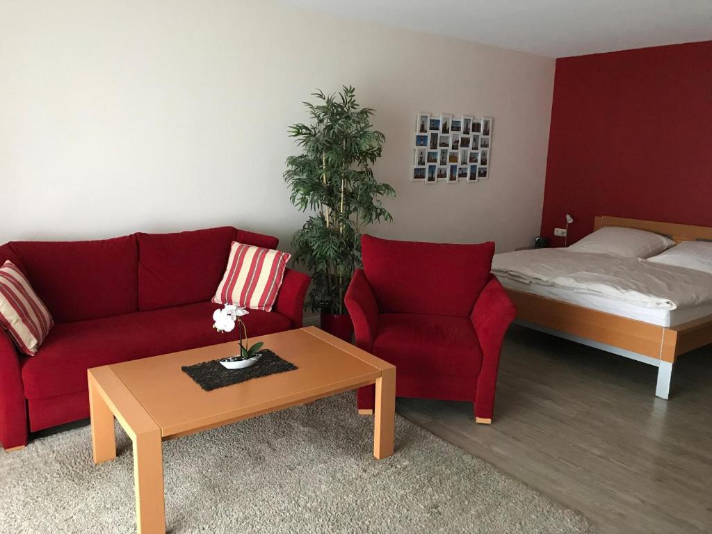 a living room with a red couch and a bed at Steiner Strandappartements Appartement 303 Seeseite in Stein