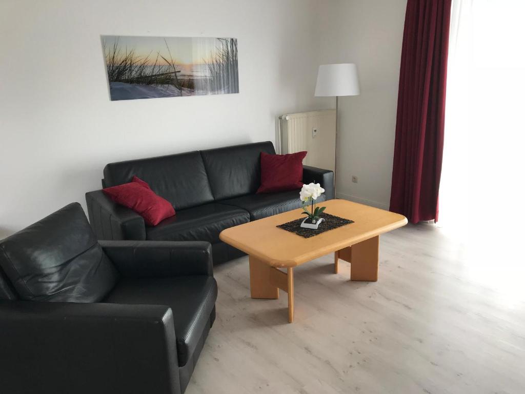 a living room with a couch and a coffee table at Steiner Strandappartements Appartement 310 Südseite mit seitlichem Meerblick in Stein