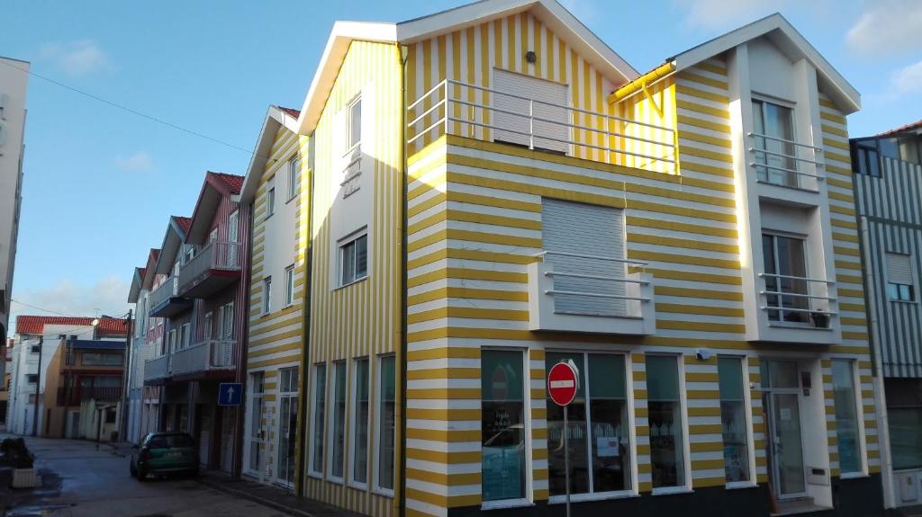 un edificio blanco y amarillo en una calle de la ciudad en Casa Fernandes - Costa Nova, en Costa Nova