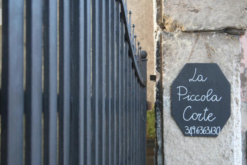 een bord aan de zijkant van een metalen hek bij B&B La Piccola Corte in Polpenazze del Garda
