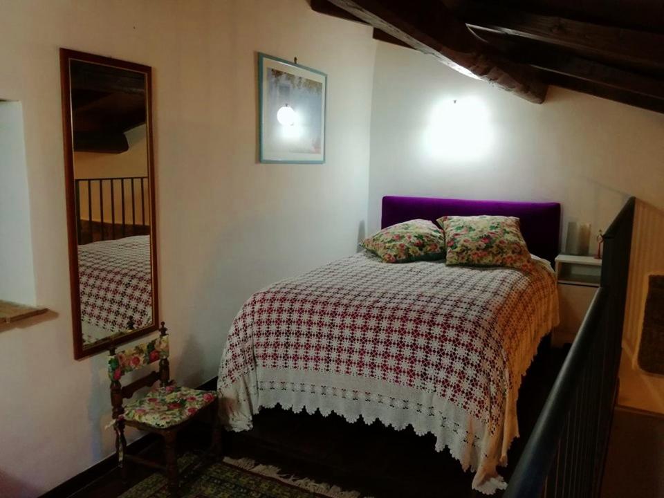 ein Schlafzimmer mit einem Bett und einem Spiegel in der Unterkunft La casa di Susanna in Viterbo