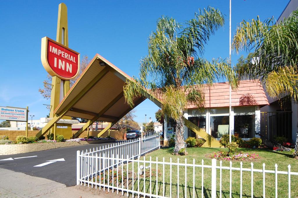 una posada de hotel con una valla blanca delante de ella en Imperial Inn Oakland, en Oakland