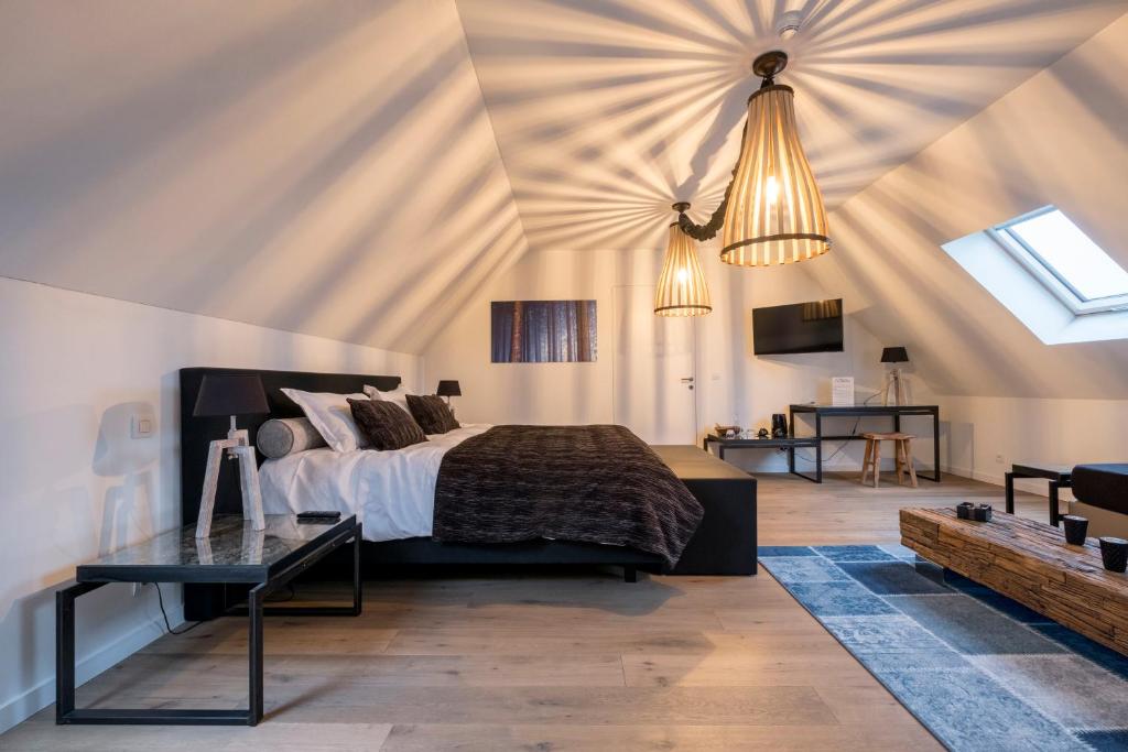 una camera con letto in una stanza con soffitto di B&B La Douceur de la Miclette a Ellezelles