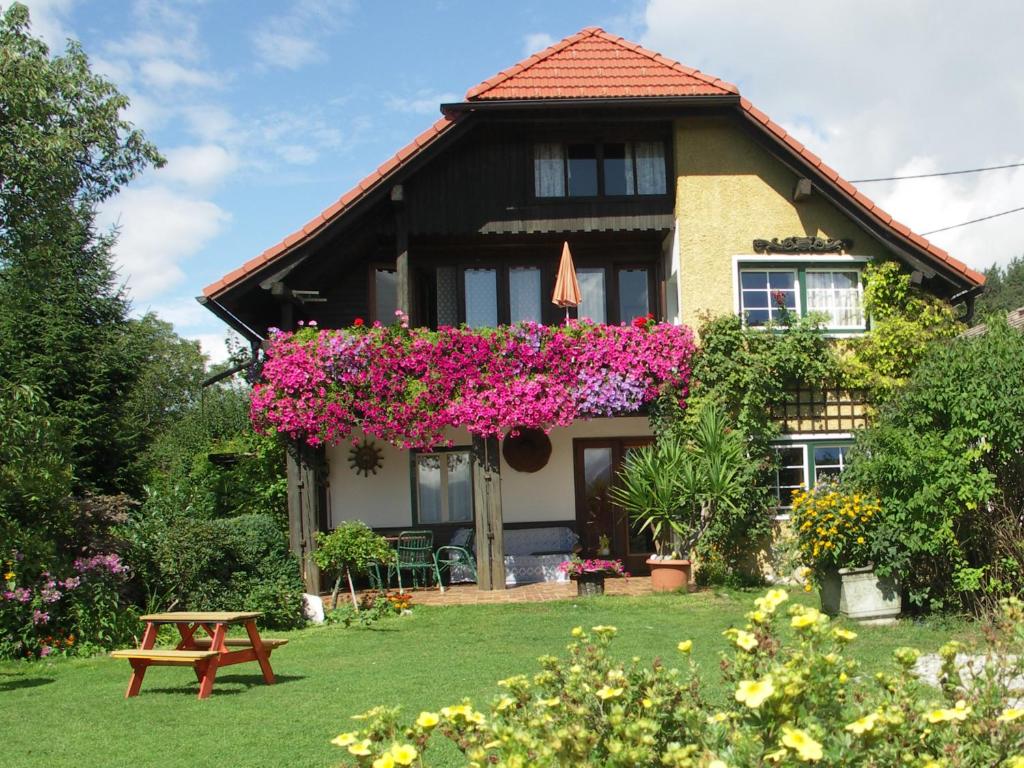 une maison avec des fleurs sur son côté dans l'établissement Landhaus Egger, à Seeboden