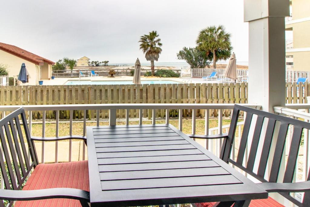 een houten tafel op een balkon met een hek bij Sunset Harbour Villas in Navarre