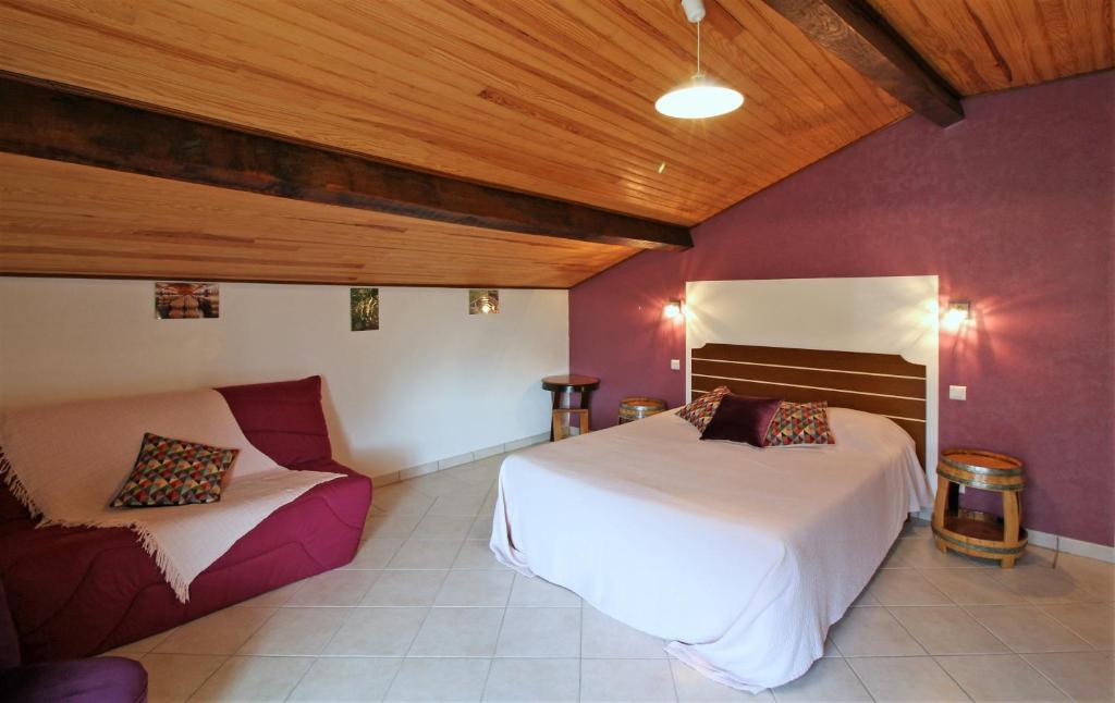 um quarto com 2 camas e um sofá em La Halte de Segondignac em Saint-Germain-dʼEsteuil