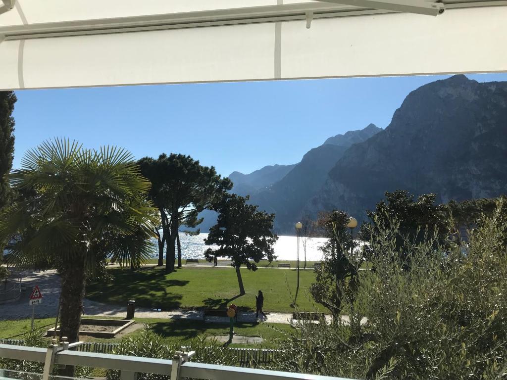 widok na park z palmami i góry w obiekcie Appartement Lago Blu w mieście Riva del Garda