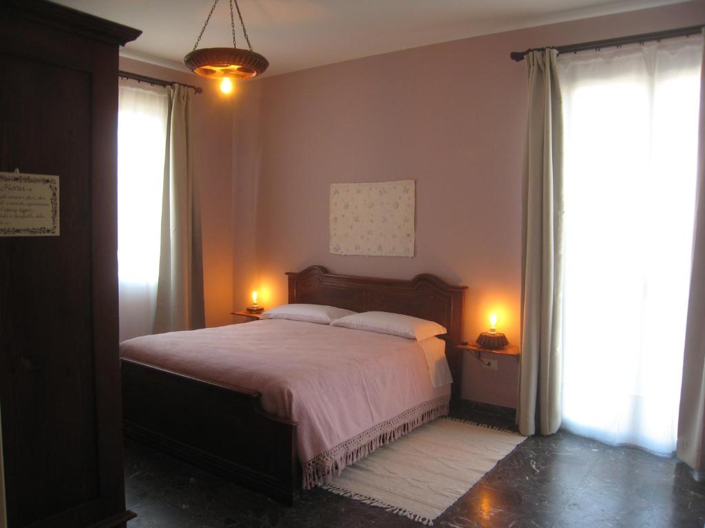 ein Schlafzimmer mit einem großen Bett und zwei Fenstern in der Unterkunft B&B Anima Natura in Modena