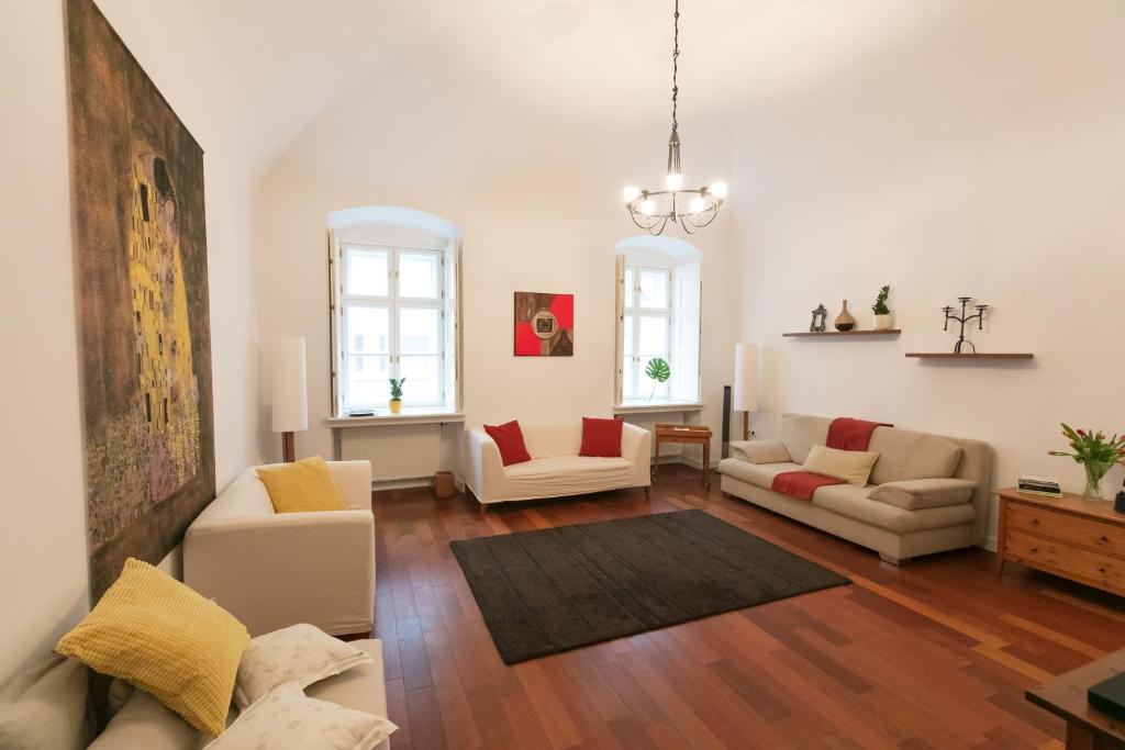 a living room with two couches and a table at Design Apartment Eger in Eger