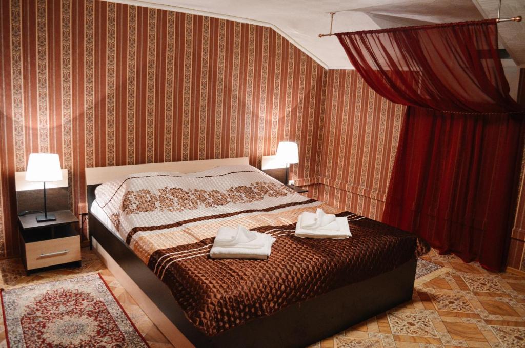 ヴォログダにあるMini-Hotel Aquarelのベッドルーム1室(ベッド1台、タオル2枚付)