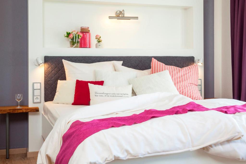 a bedroom with a large bed with red and white pillows at Landhotel Rosenschänke in Kreischa