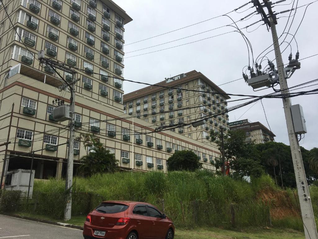 un'auto rossa parcheggiata di fronte a un edificio di Estudio Itaipava a Itaipava