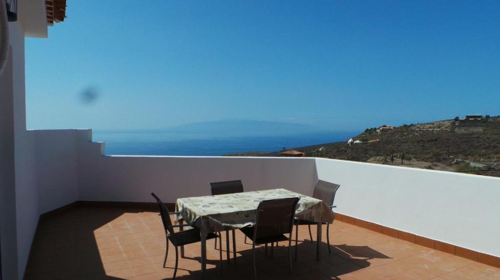 a table and chairs on a balcony with a view of the ocean at Casa mirador in Adeje