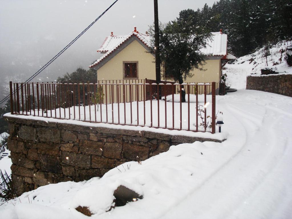 une maison avec une clôture dans la neige dans l'établissement Casa de São Sebastião, à Manteigas