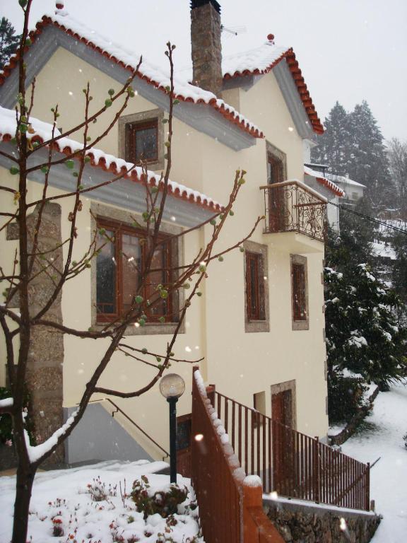 a house covered in snow with a fence at Casa de São Sebastião in Manteigas