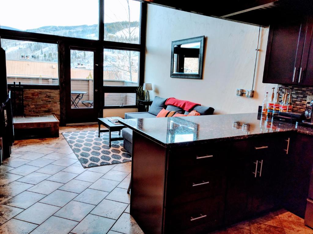 a kitchen with a counter top and a living room at Vail View Loft - Slope-view condo, free bus for quick access to Vail Village in Vail