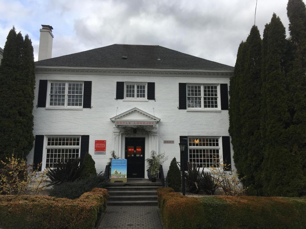 una casa blanca con persianas negras y una puerta principal en Doyle Lovejoy, en Portland