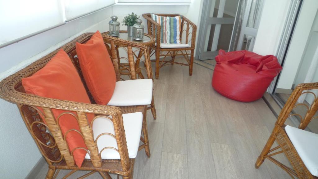 a room with chairs and a table with a red bag at Casa Mar in Costa da Caparica