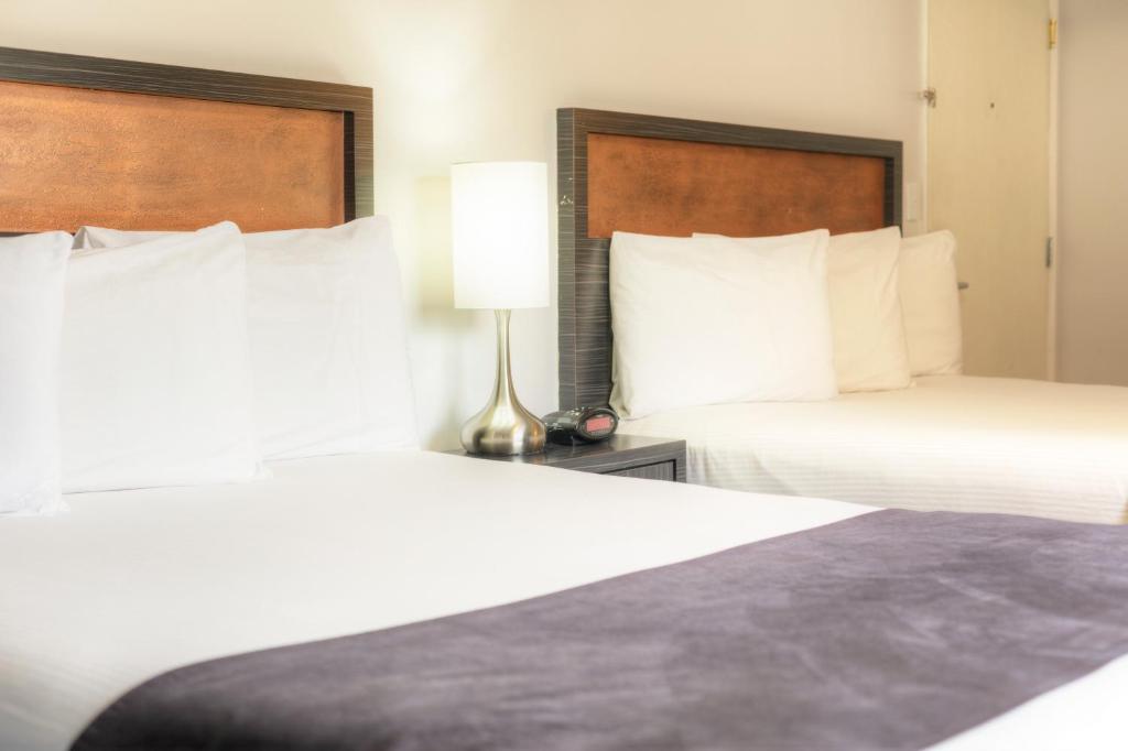 a hotel room with two beds and a lamp at Hotel Ruby in Spokane
