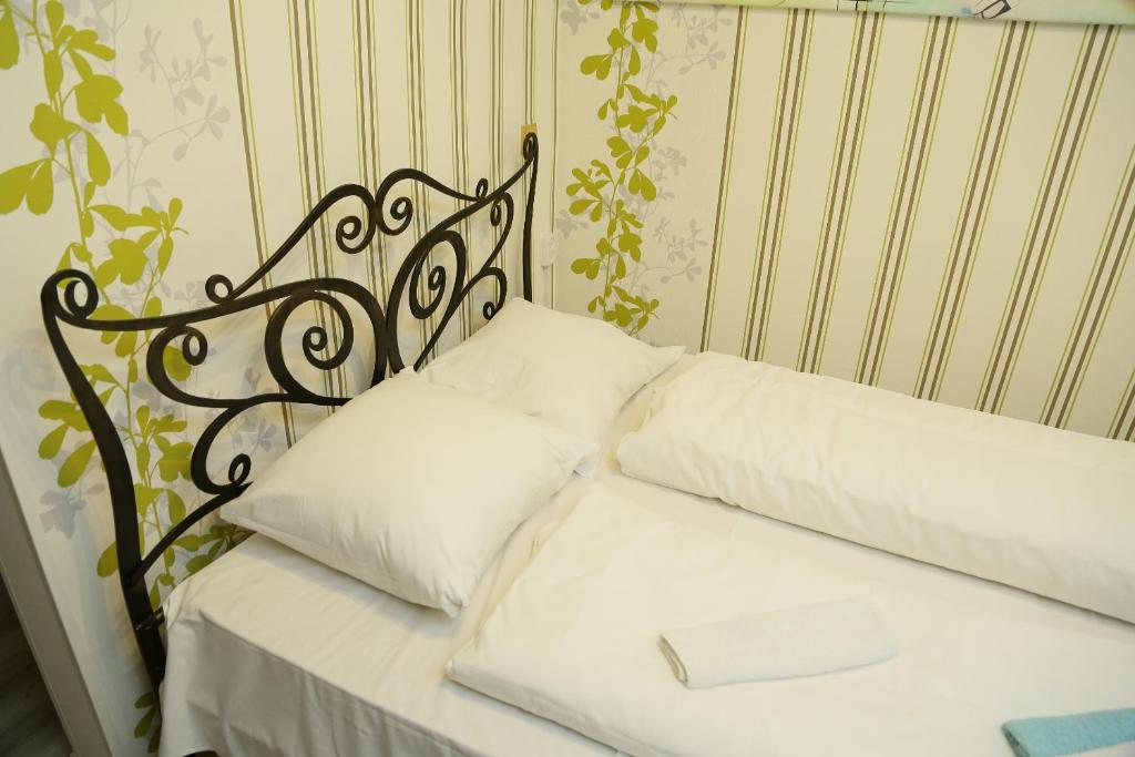 カリーニングラードにあるУютные апартаменты у Верхнего озераのベッド(白い枕、黒い頭板付)
