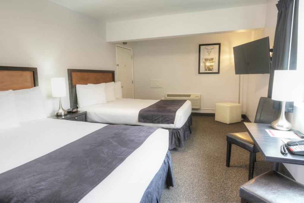 a hotel room with two beds and a desk at Hotel Ruby in Spokane