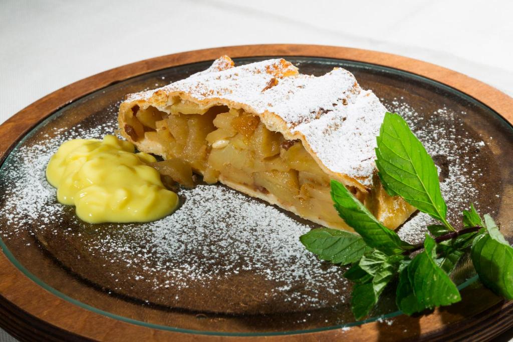 a piece of pie with powdered sugar on a plate at Hotel Chalet Sas Morin in Pozza di Fassa