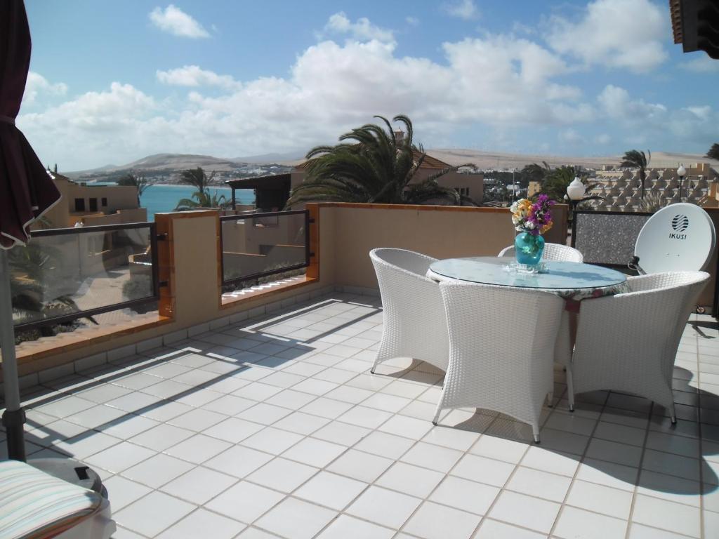 un patio con mesa y sillas en la azotea en Ferienhaus Vista Mar, en Costa Calma