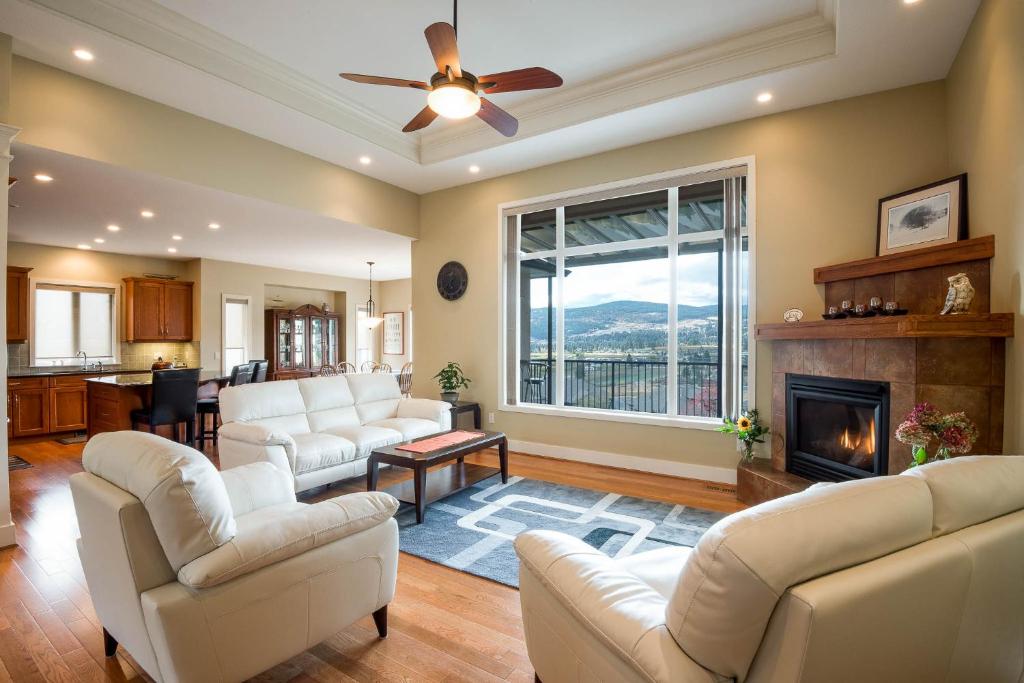 a living room with white furniture and a fireplace at Adela's Bed and Breakfast in West Kelowna