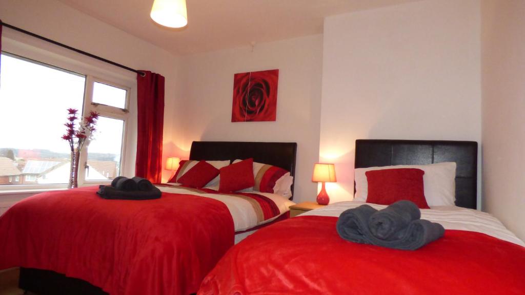 two beds in a room with red and white at Boythorpe House in Chesterfield