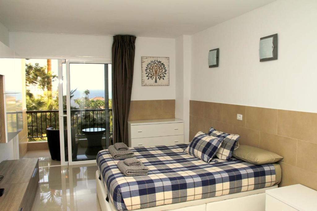 um quarto com uma cama e uma varanda em Las Americas Tenerife em Playa de las Americas
