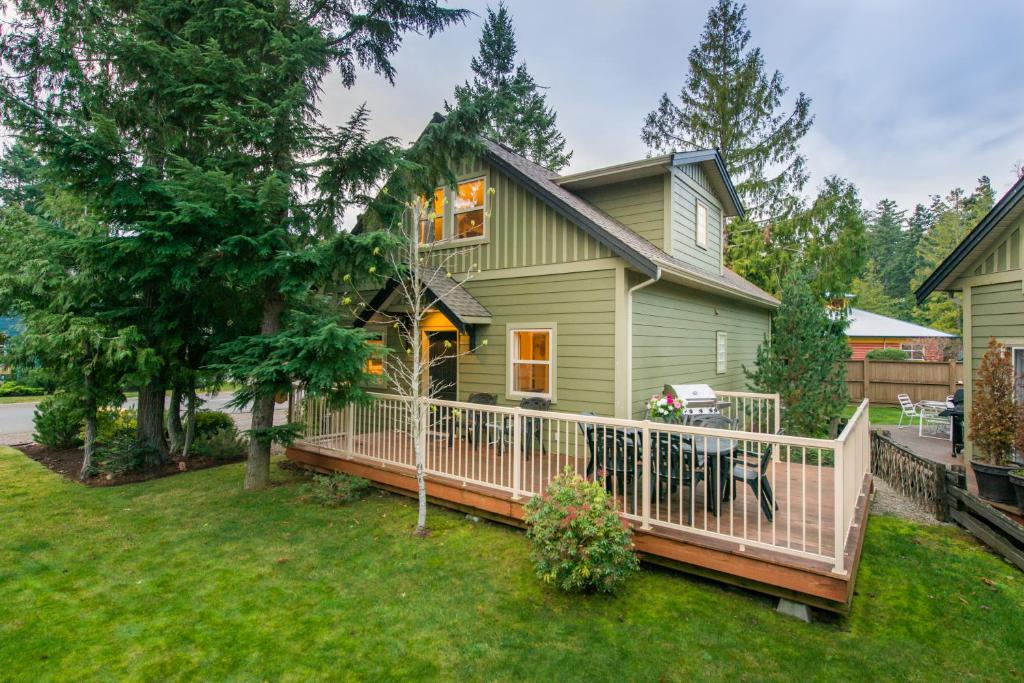 ein Haus mit einer Veranda mit einem weißen Zaun in der Unterkunft Oceanside Village Resort in Parksville