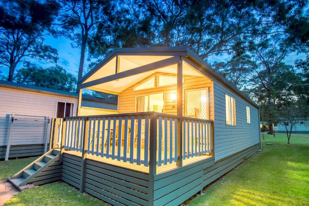 a small cabin with a screened porch in a yard at Tasman Holiday Parks - Kioloa Beach in Kioloa